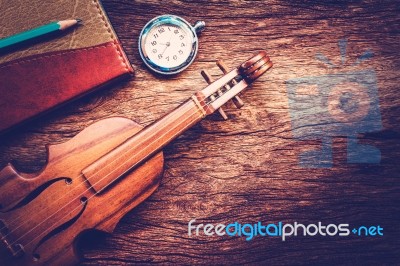 Violin And Notebook With Pencil On Grunge Dark Wood Background Stock Photo