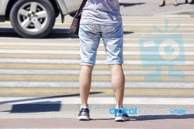 Waiting Young Man At The Pedestrian Crossing And Car Traffic Stock Photo