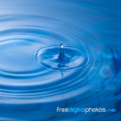 Water Drop Falling Into Water Making A Perfect Droplet Splash Stock Photo