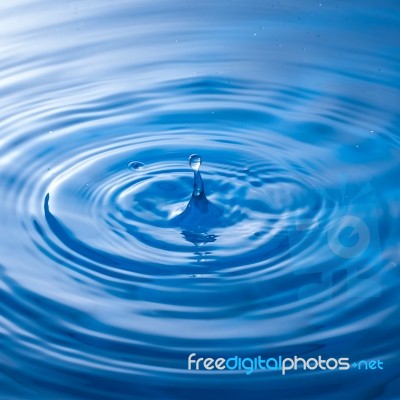 Water Drop Falling Into Water Making A Perfect Droplet Splash Stock Photo