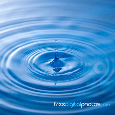 Water Drop Falling Into Water Making A Perfect Droplet Splash Stock Photo