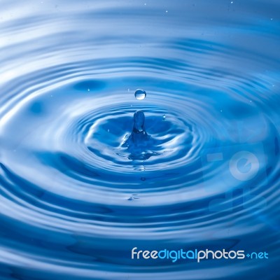 Water Drop Falling Into Water Making A Perfect Droplet Splash Stock Photo