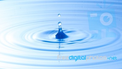 Water Drop Impact With Water Surface, Causing Rings On The Surface Stock Photo