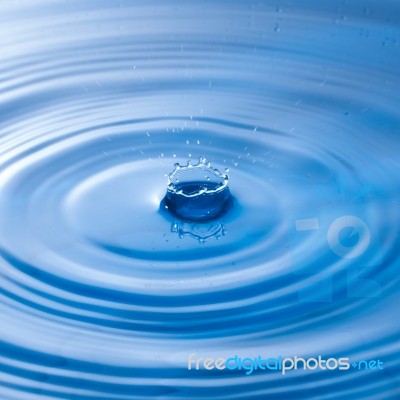 Water Drop Impact With Water Surface, Causing Rings On The Surface Stock Photo