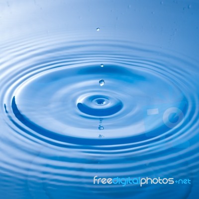 Water Drop Impact With Water Surface, Causing Rings On The Surface Stock Photo