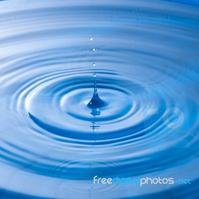 Water Drop Impact With Water Surface, Causing Rings On The Surface Stock Photo