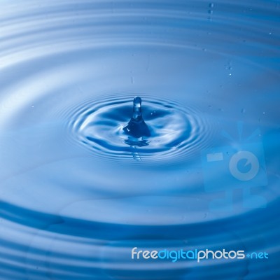 Water Drop Impact With Water Surface, Causing Rings On The Surface Stock Photo