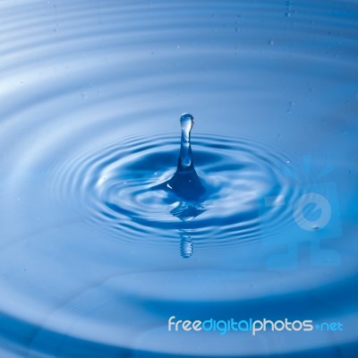 Water Drop Impact With Water Surface, Causing Rings On The Surface Stock Photo