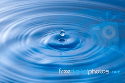Water Drop Impact With Water Surface, Causing Rings On The Surface Stock Photo