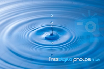 Water Drop Impact With Water Surface, Causing Rings On The Surface Stock Photo