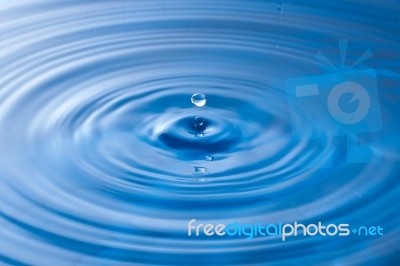 Water Drop Impact With Water Surface, Causing Rings On The Surface Stock Photo