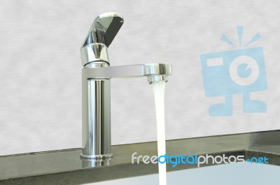 Water Flow Faucet Granite Counter On Cement Wall Stock Photo
