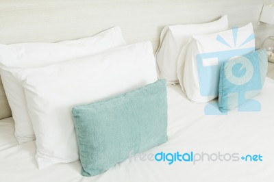 White And Green Pillows On Bed Stock Photo