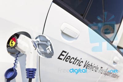 White Electric Car Charging Stock Photo