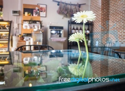 White Gerbera Flower Decorated Glass Table Stock Photo