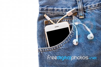 White Smartphone In Your Pocket Blue Jeans With Earphone And Usb Cable For Transfer Data Or Information On Isolated Background Stock Photo