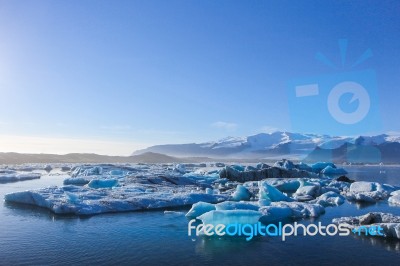 Wide Landscape Of Icebergs Floating On The Water Under The Very Clear Blue Sky With Copy Space Stock Photo
