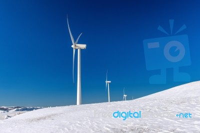 Wind Turbine And Blue Sky In Winter Landscape Stock Photo