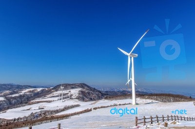 Wind Turbine And Blue Sky In Winter Landscape Stock Photo