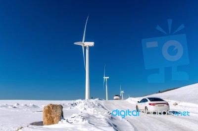 Wind Turbine And Car With Blue Sky In Winter Landscape Stock Photo