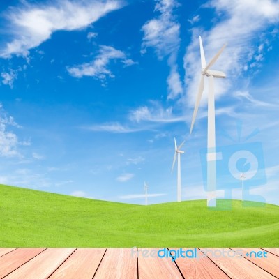 Wind Turbine On Green Grass Field And Blue Sky Background Stock Photo