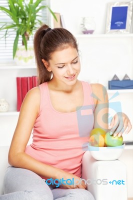 Woman At Home On Sofa With Fruits Stock Photo