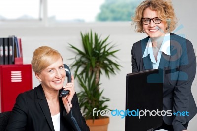 Woman Attending Call With Colleague Stock Photo