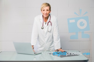 Woman Doctor Standing Behind Desk Stock Photo