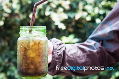 Woman Hand Holding Iced Soda In Green Glass Stock Photo