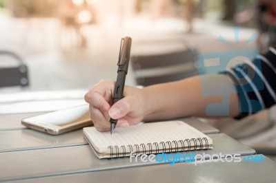 Woman Hand Writing On Notepad Stock Photo