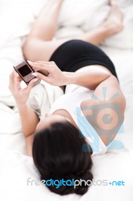 Woman In Bed With Mobile Phone Stock Photo