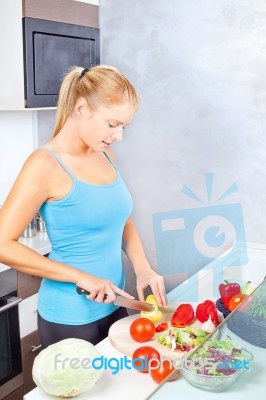 Woman In Kitchen Cutting Vegetables Stock Photo