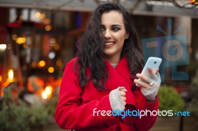 Woman In Red Coat With Mobile Phone In Hands, Smartphone, Urban Stock Photo