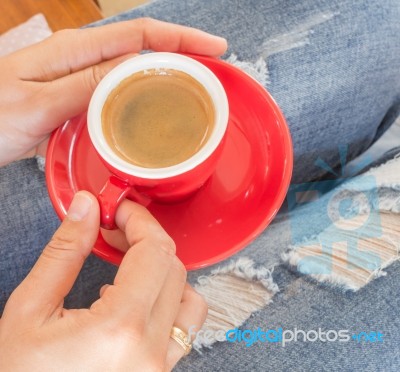 Woman In Torn Jeans Sitting At Coffee Shop Stock Photo