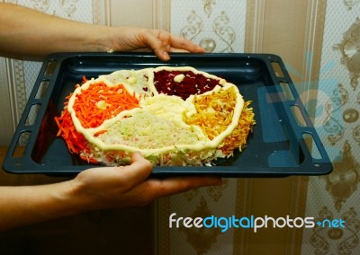 Woman Is Holding A Baking Sheet With A Salad In The Form Of Cake… Stock Photo