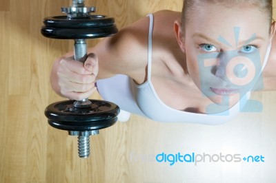 Woman Lifting Dumbbell In Gym Stock Photo