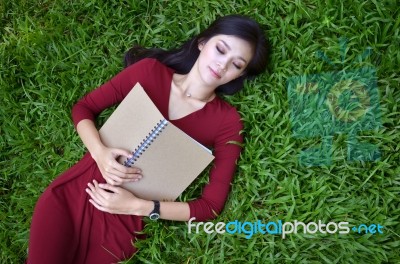 Woman Lying On Green Grass With  Book Stock Photo