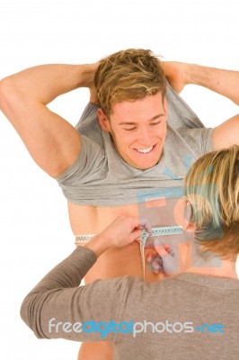 Woman Measuring Chest Of Young Man Stock Photo