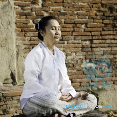 Woman Meditating Against Ancient Temple Stock Photo