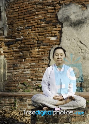Woman Meditating In Temple Stock Photo