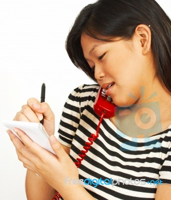 Woman On Phone Taking Notes Stock Photo