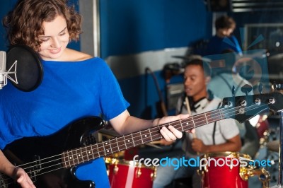 Woman Playing Guitar In Recording Studio Stock Photo