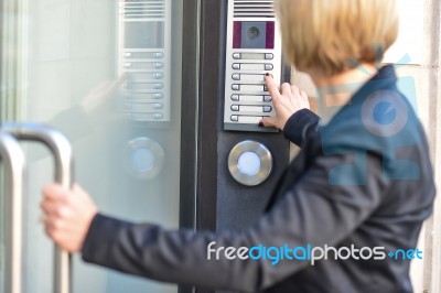 Woman Pushing A Intercom Button Stock Photo