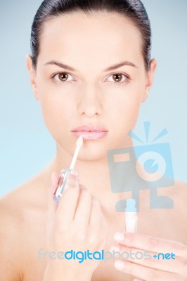 Woman Putting Lipstick On Her Lips Stock Photo