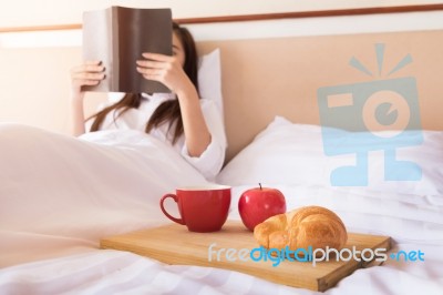 Woman Reading Book  And Drinking Coffee On Bed During The Mornin… Stock Photo