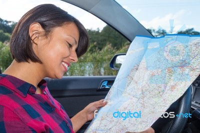 Woman Reading Road Map In Car Outdoors Stock Photo
