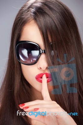 Woman Showing The Sign For Silence With Her Index Finger Stock Photo