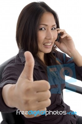 Woman Showing Thumbs Up While Talking Stock Photo