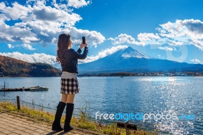Woman Use Mobile Phone Take A Photo At Fuji Mountains, Kawaguchiko Lake In Japan Stock Photo