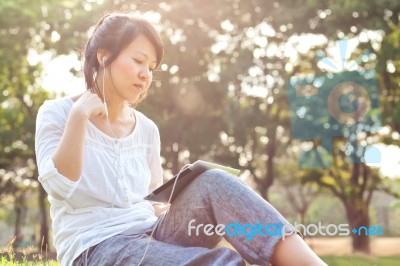Woman Using Digital Tablet In Park Stock Photo